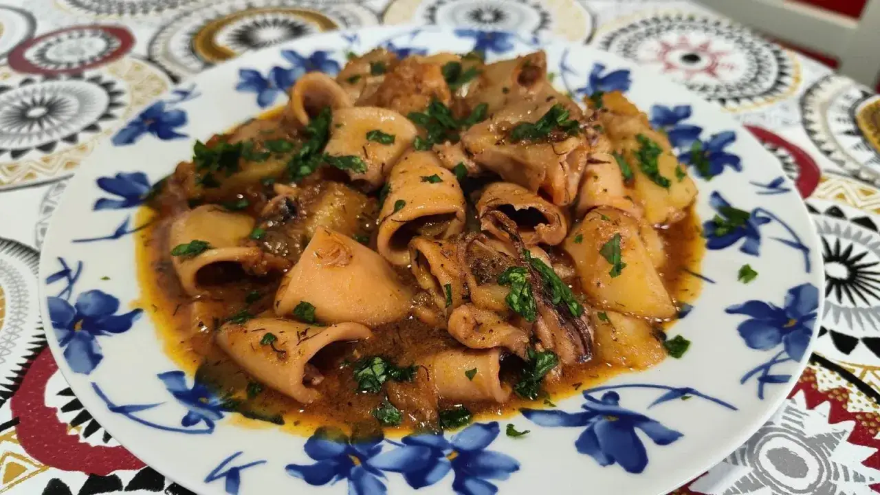 Calamares en salsa, un plato casero con trozos tiernos de calamar bañados en una rica salsa, espolvoreados con perejil fresco.