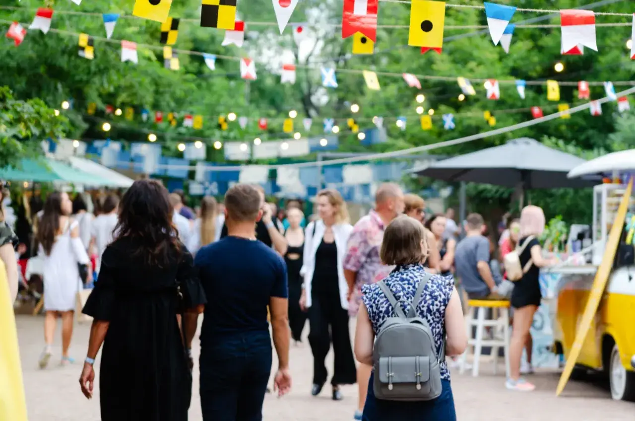 Bunte Flaggen schmücken die Havixbeck Veranstaltungen. Menschen schlendern über einen belebten Markt mit Ständen und Essen.