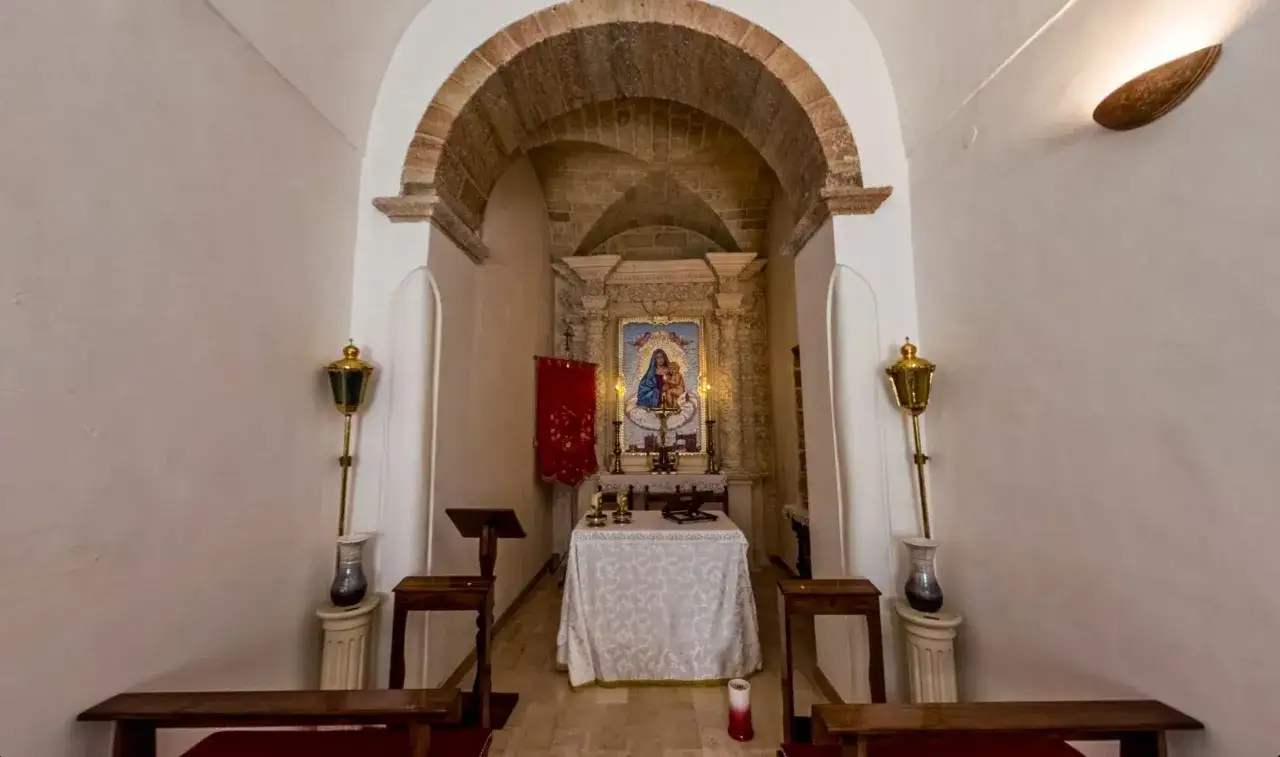 Interno di una cappella semplice, con un mosaico della Madonna e Bambino sull'altare. Avetrana qui non &egrave; Hollywood, ma un luogo di pace e devozione.