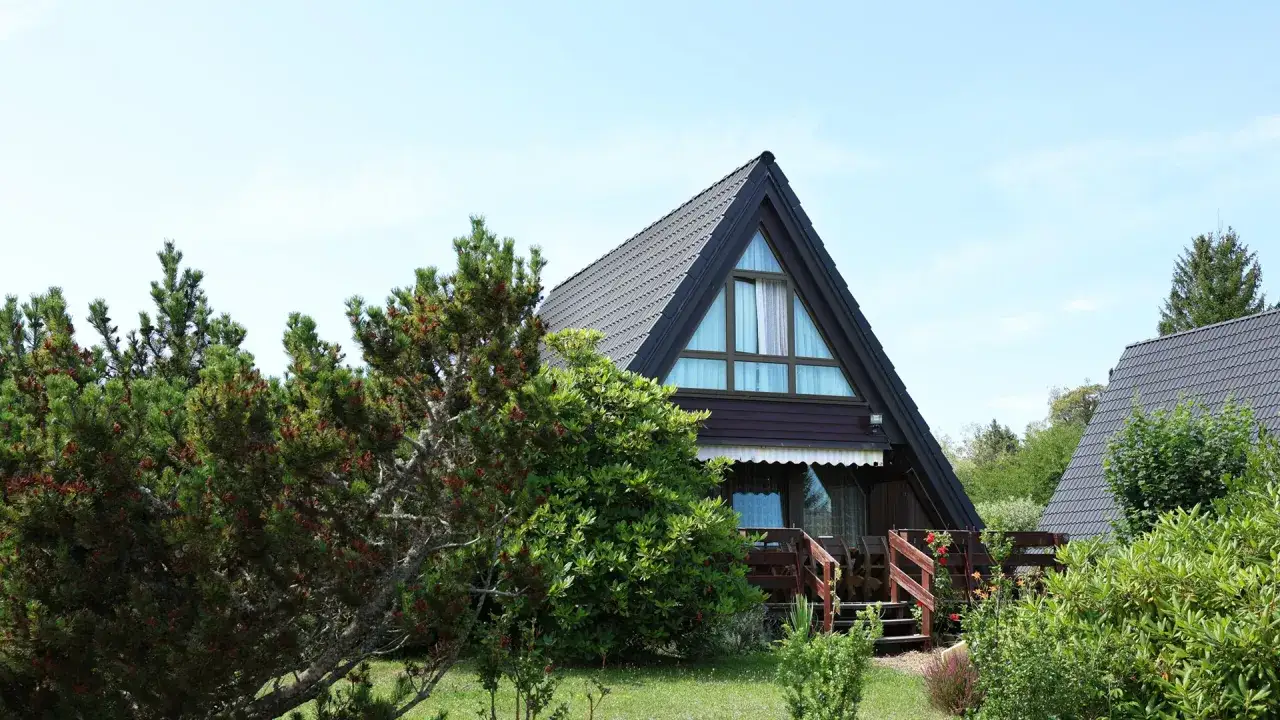 Ferienhäuser im neuen Center Parcs Schwarzwald, umgeben von grünen Bäumen und Sträuchern.