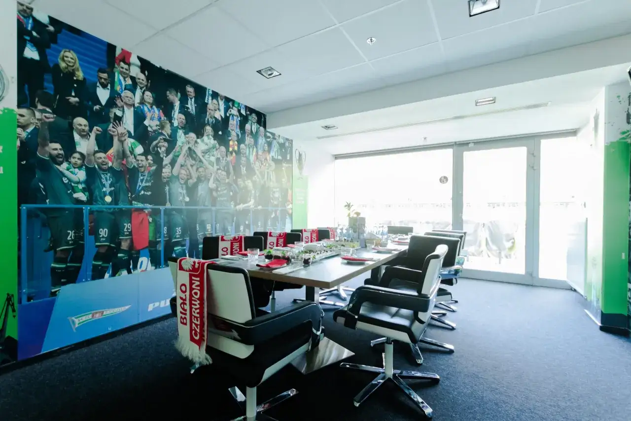 St&oacute;ł konferencyjny z widokiem na stadion. Na ścianie mural z piłkarzami. Idealne miejsce na zwiedzanie stadionu Gdańsk i om&oacute;wienie strategii.
