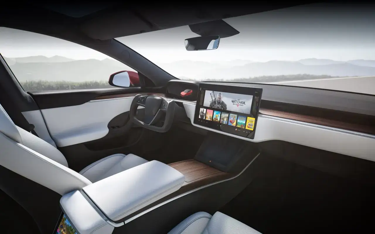 Wnętrze Tesli z ekranem pokazującym gry. Zastanawiasz się, ile kosztuje najdroższa Tesla, gdy możesz grać w Wiedźmina?