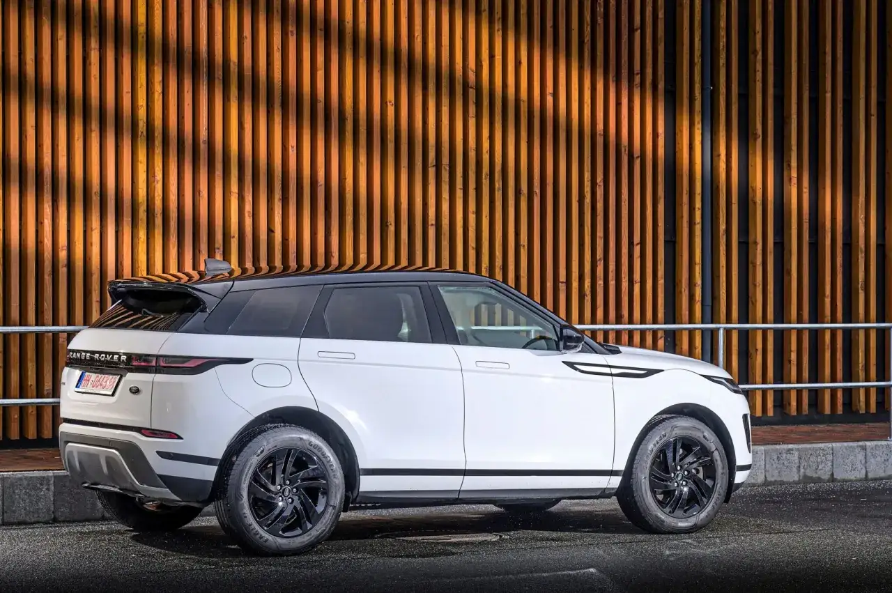 Weißer Range Rover Evoque 2.0 Diesel, moderne Optik vor Holzfassade. Gute Erfahrungen mit diesem Modell sind zu erwarten.