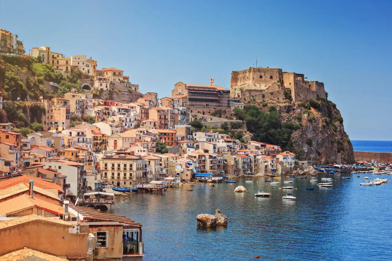 Scilla, uno dei borghi più suggestivi della Calabria, con le sue case colorate aggrappate alla roccia e il castello che domina il mare.