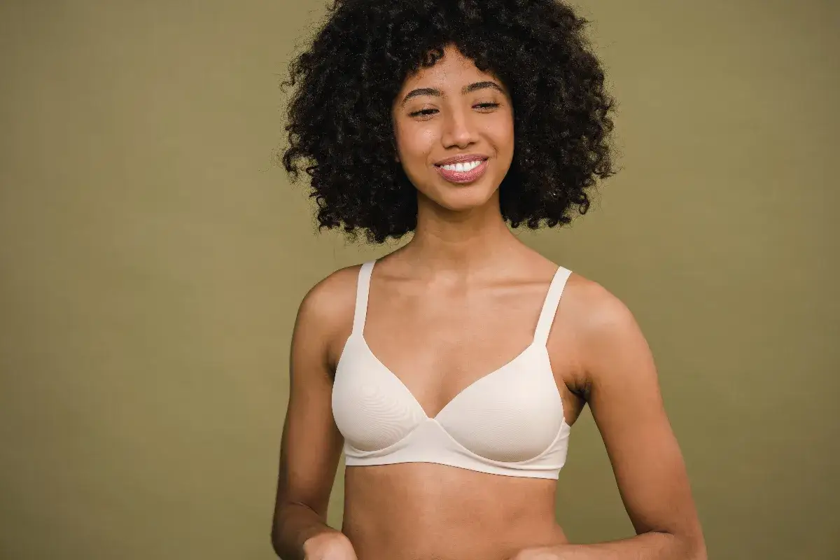 Donna sorridente con un reggiseno stretto, quasi una tachicardia per l'emozione.