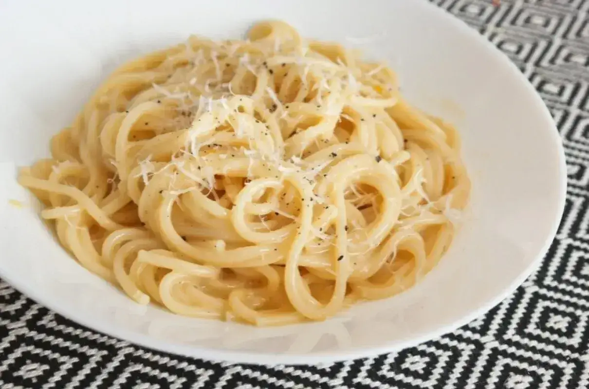Spaghetti carbonara - przepis oryginalny ze śmietaną. Pyszne danie z makaronem, posypane parmezanem i pieprzem.
