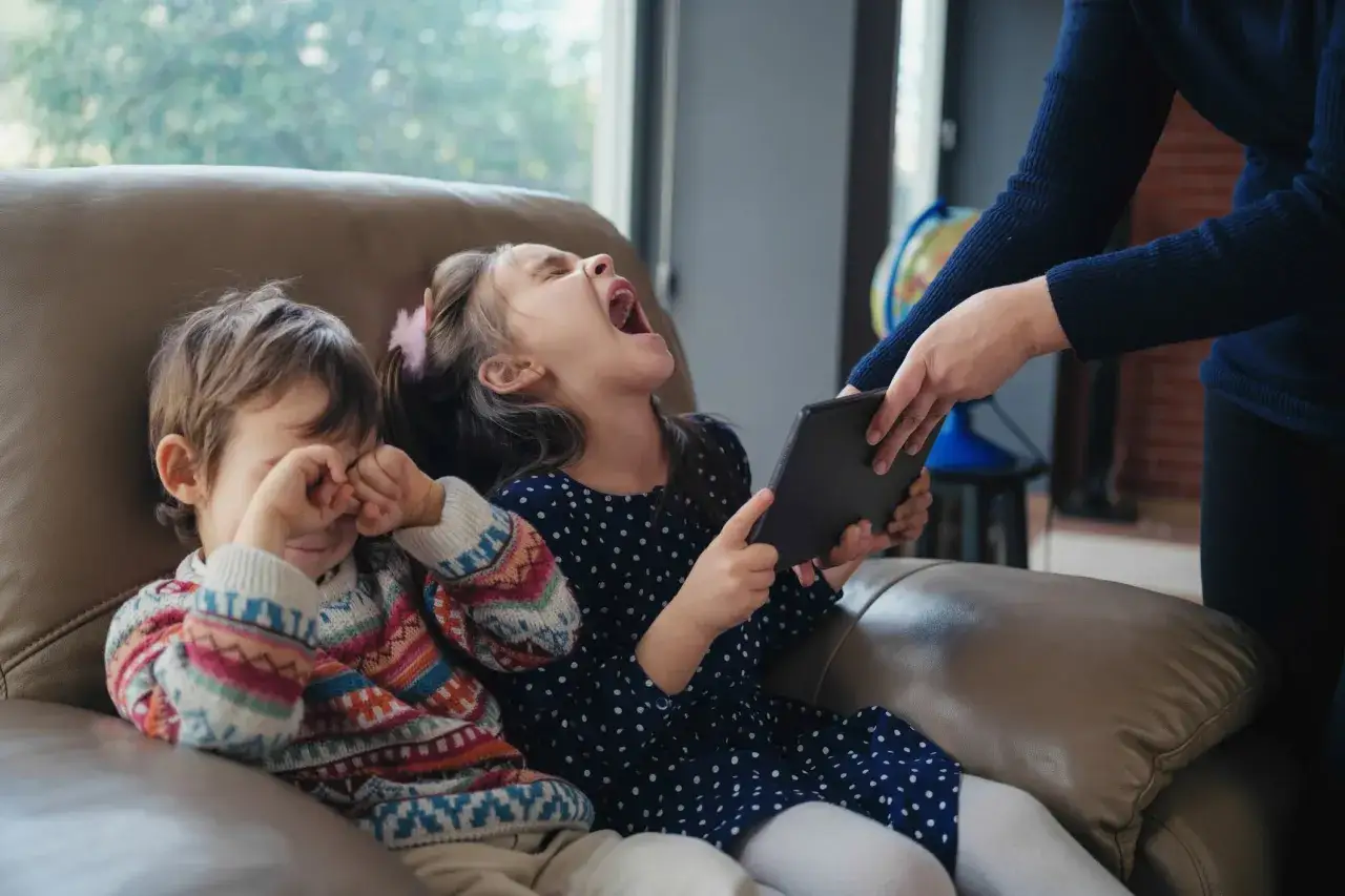 Niño llora mientras su hermana grita por una tableta. Mi hijo de 3 años me pega, ¡qué lío!