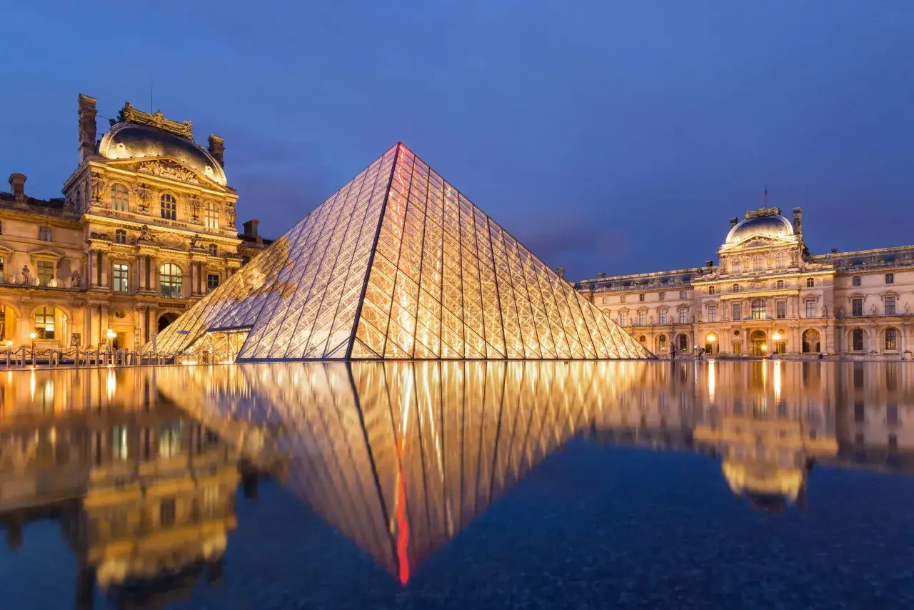Der beleuchtete Louvre mit seiner Glaspyramide ist ein Muss in Paris. Die Spiegelung im Wasser bei Nacht ist magisch.