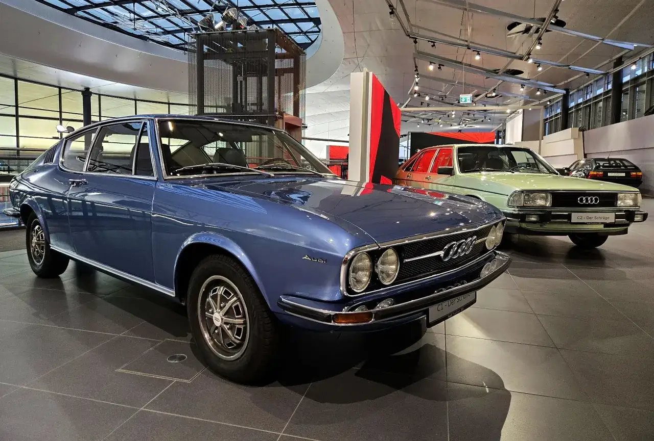 Niebieskie Audi 100 Coupé S z lat 70. obok zielonego Audi 100 C2.