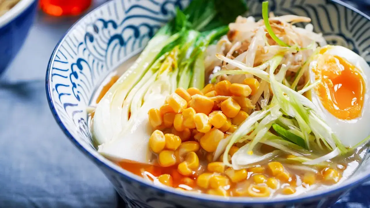 En sk&aring;l med vegetarisk ramen, fylld med majs, b&ouml;ngroddar, pak choi och ett perfekt kokt &auml;gg.