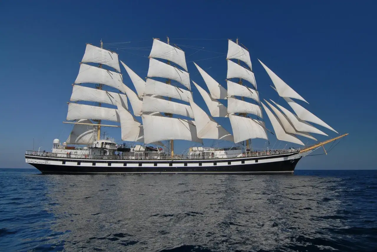 Vela spiegata su un veliero maestoso, un alto bordo che simboleggia avventura e libertà sul mare blu.
