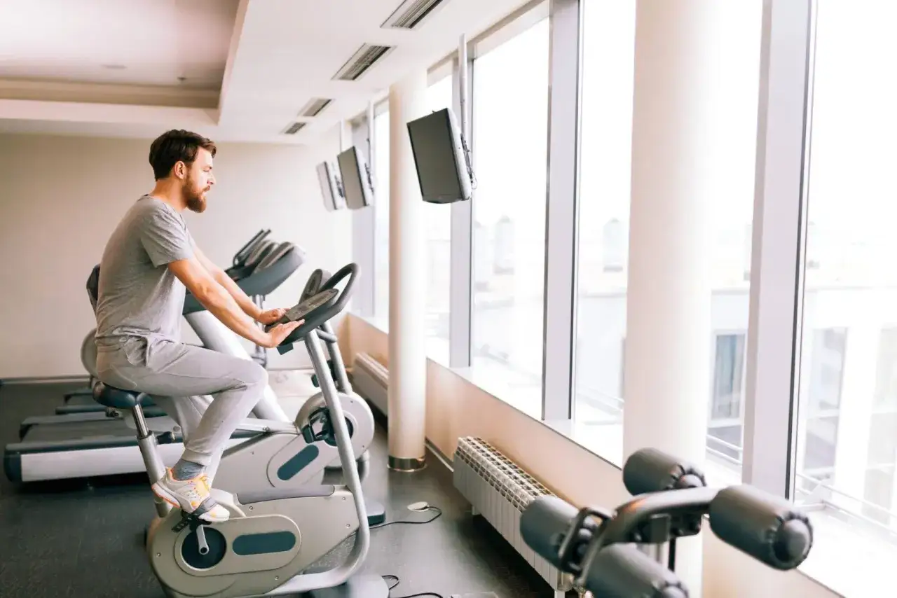 Mężczyzna ćwiczy na rowerze stacjonarnym, kt&oacute;ry może być dobrym wyborem, jeśli zastanawiasz się, jaki rower stacjonarny do rehabilitacji kolana.