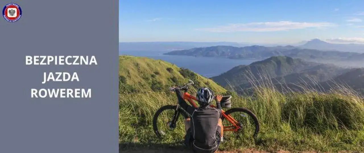 Rowerzysta w kasku odpoczywa na szczycie góry, podziwiając widok. Tekst