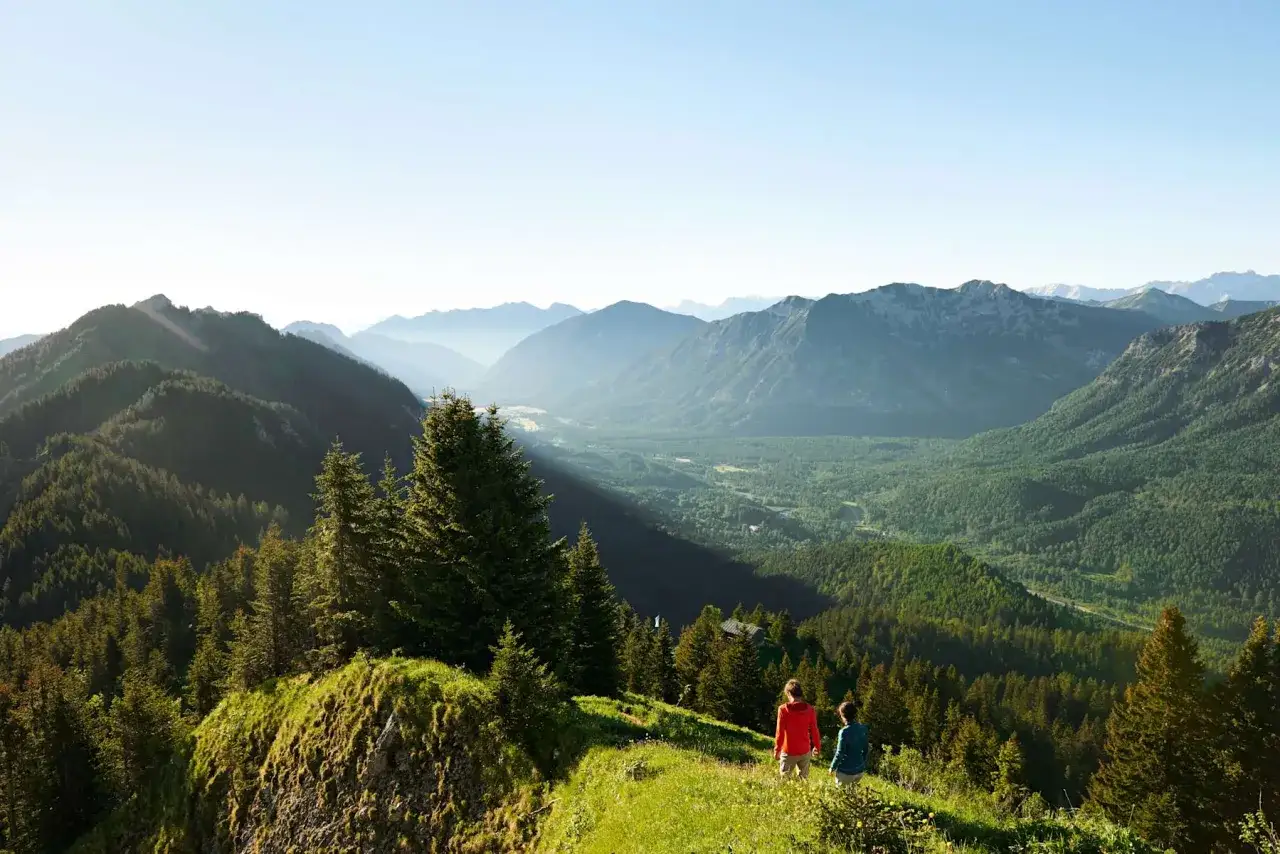 Zwei Wanderer genie&szlig;en die Aussicht auf eine Berglandschaft w&auml;hrend einer Kolbensattel Wanderung.