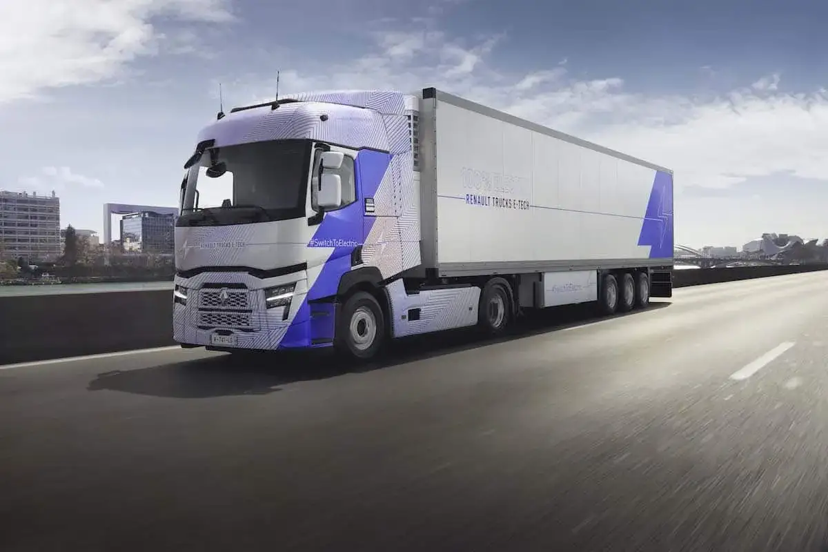 Un camion renault electrique aux lignes futuristes roule sur une autoroute, arborant un motif bleu et blanc.