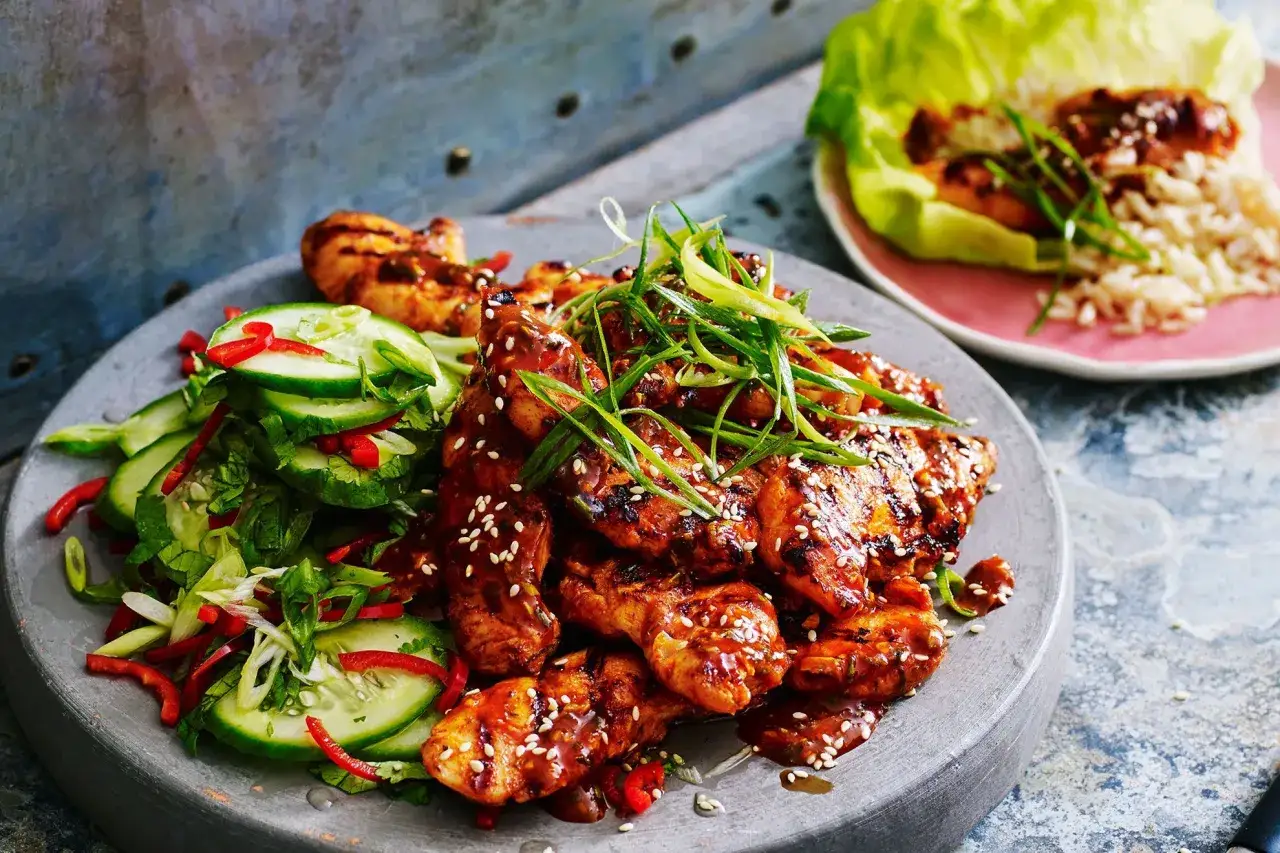 Läckert koreansk kyckling med sesamfrön och en fräsch gurksallad. Serveras med ris och salladsblad.