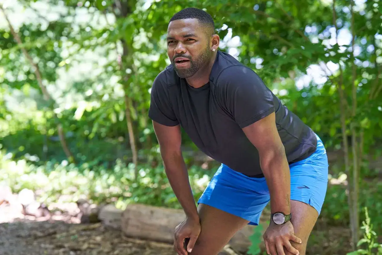 Ein Mann im Wald macht eine Trainingspause. Eine Woche Trainingspause ist sinnvoll für die Erholung.