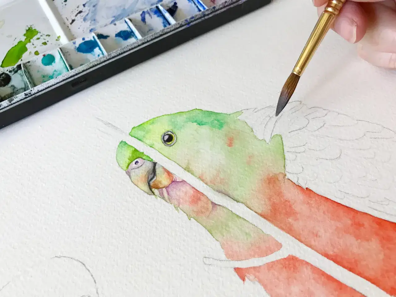 Une main utilise un pinceau pour peindre un dessin d'oiseau aux couleurs vives.
