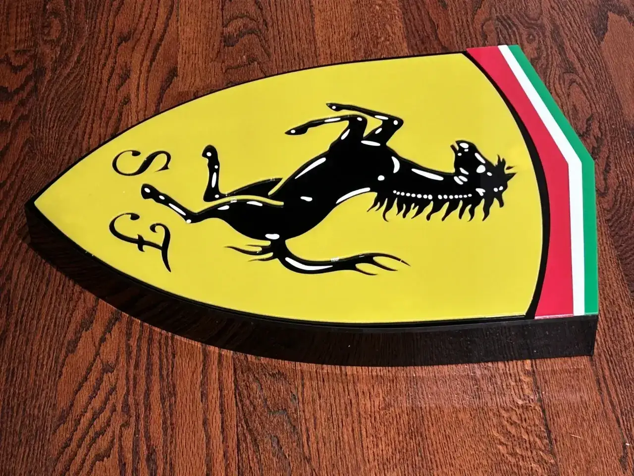 Jaki znaczek ma Ferrari? To żółta tarcza z czarnym koniem i literami 