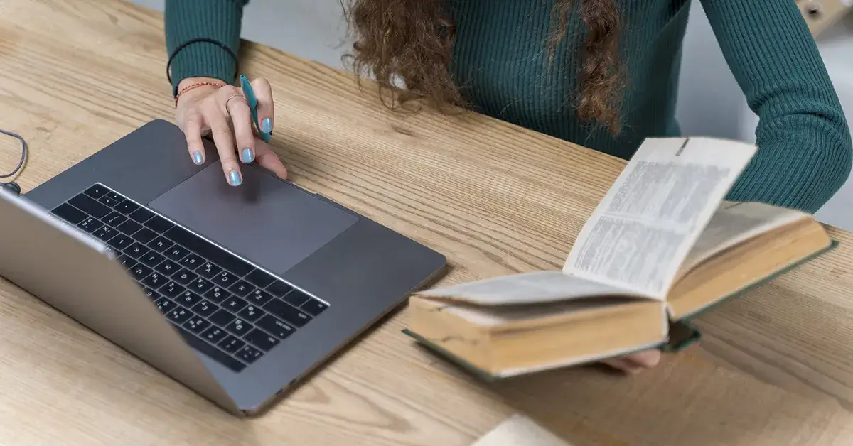 słownik papierowy i laptop na biurku