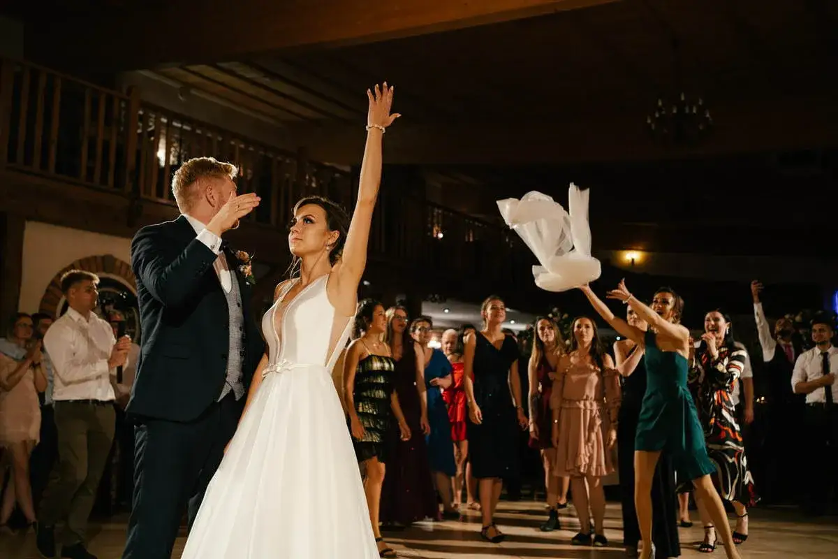 Panna młoda rzuca welonem podczas oczepin. To tradycja, która symbolizuje przejście do nowego etapu życia.