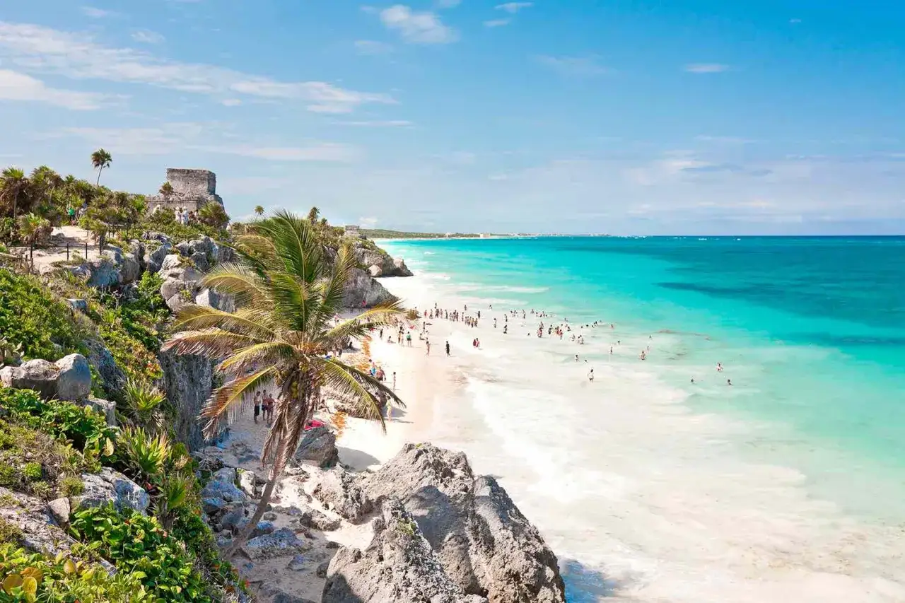 Traumhafter Strand mit t&uuml;rkisfarbenem Wasser und Ruinen in Mexiko im Januar. Viele Menschen genie&szlig;en die Sonne und das Meer.