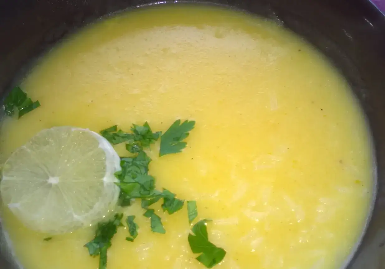 Aromatyczna zupa cytrynowa z plasterkiem limonki i natką pietruszki.