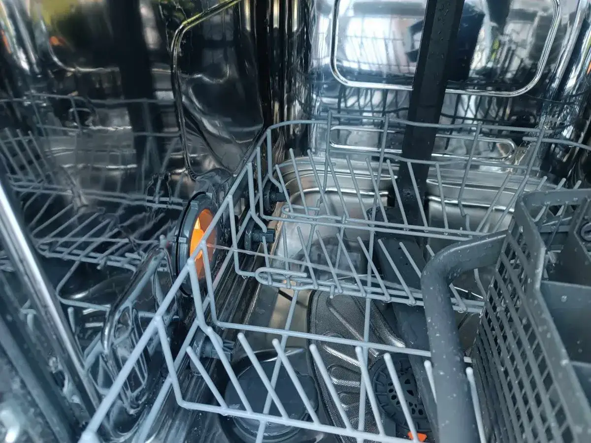 Wnętrze zmywarki Electrolux z widocznym błędem i30. Kosze na naczynia, elementy grzewcze i filtry.