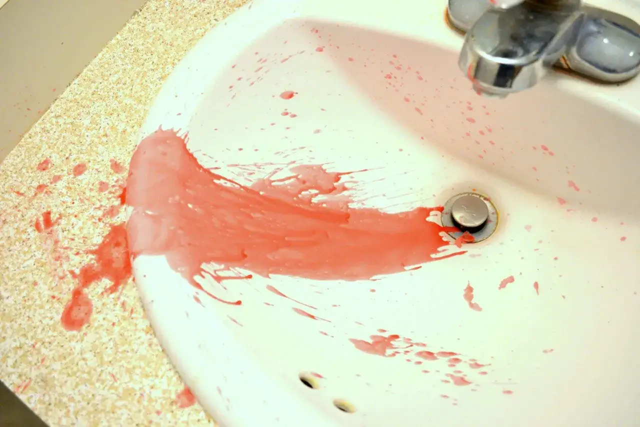 Rozlany czerwony wosk w umywalce. Jak zmyć wosk? Gorąca woda i detergent powinny pom&oacute;c.