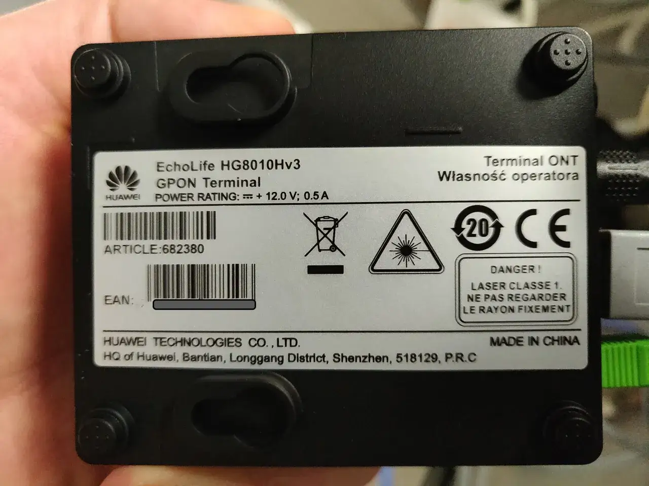 Terminal ONT Huawei EchoLife HG8010Hv3 GPON. Urządzenie zasilane 12V/0.5A, posiada oznaczenie CE i ostrzeżenie o laserze klasy 1.