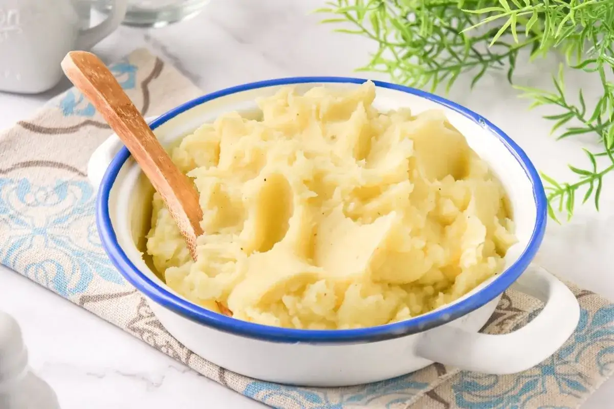 Un tazón de cremoso puré de patatas, listo para servir. Aprende como hacer puré de patatas perfecto.