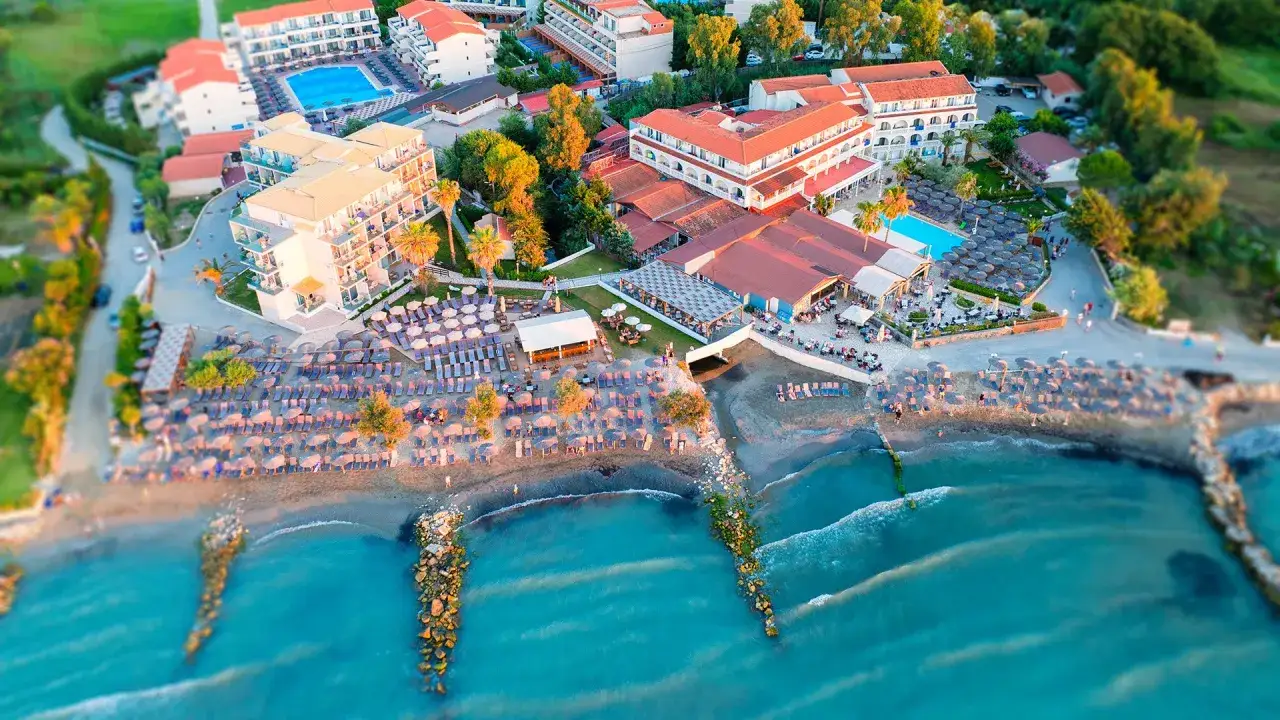 Widok z lotu ptaka na hotel przy plaży z leżakami i parasolami. Idealne miejsce na wakacje, zgodnie z wieloma angela beach opinie.