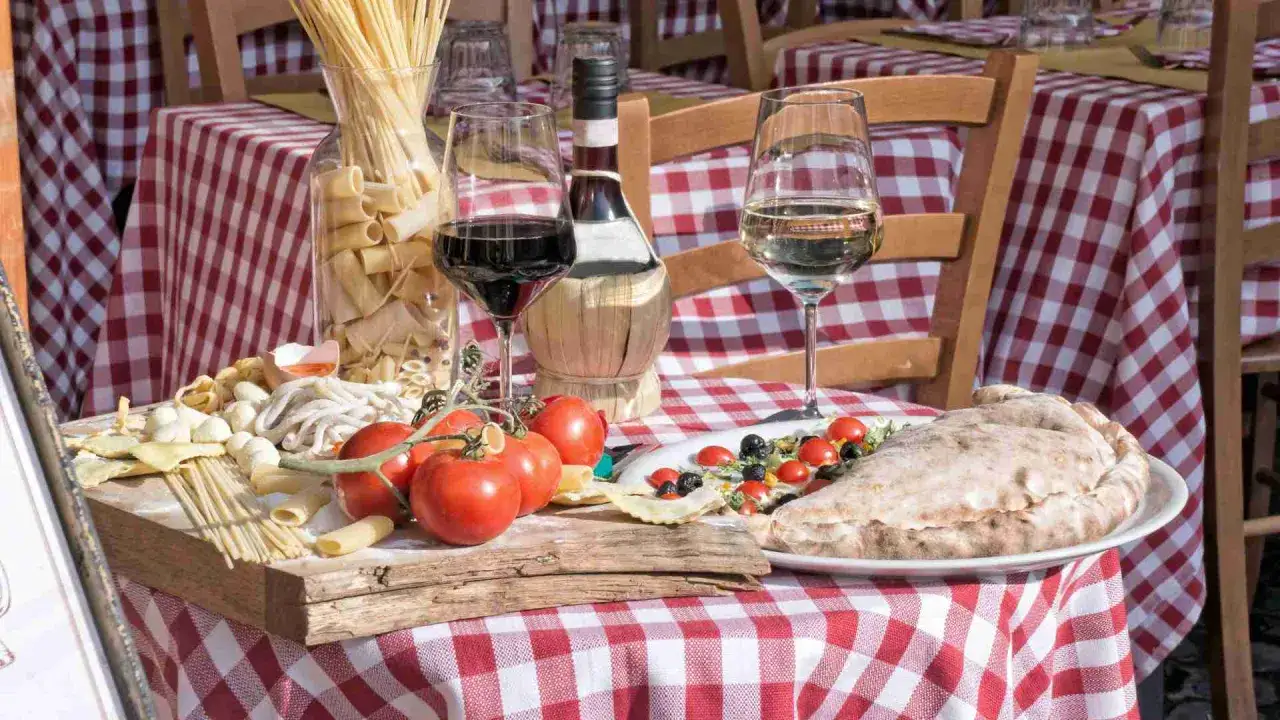Włoska uczta: makarony, pomidory, pizza i wino. To właśnie **la dolce vita co to znaczy** – słodkie życie w prostocie.