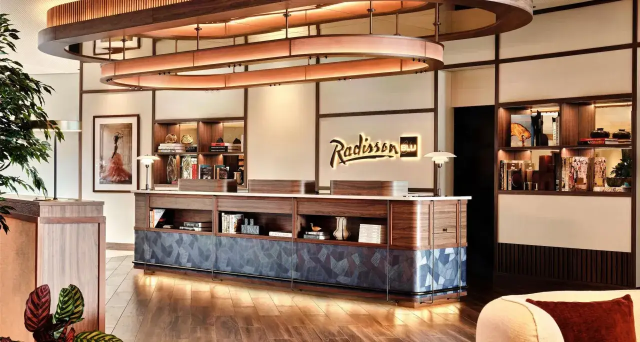 Eleganckie lobby hotelu Radisson Blu Hamburg Airport z recepcją, oświetleniem i dekoracjami.