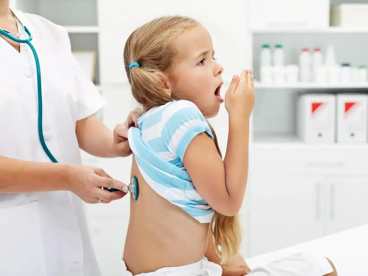 Bambina tossisce, medico ascolta i polmoni. Possibili broncopolmonite sintomi.