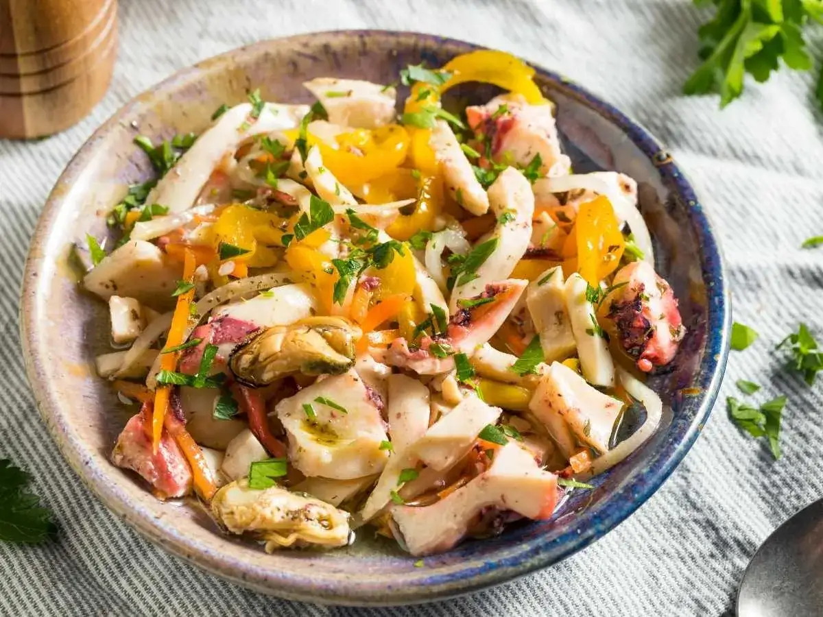 Un refrescante salpicón de marisco con pulpo, mejillones y pimientos amarillos, aderezado con perejil fresco.