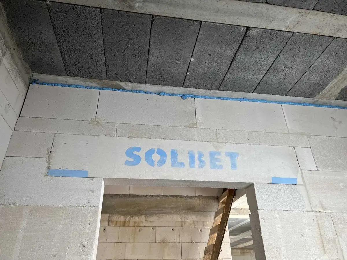 Dylatacja posadzki w trakcie budowy. Widoczne bloczki betonowe, pianka montażowa i napis SOLBET.