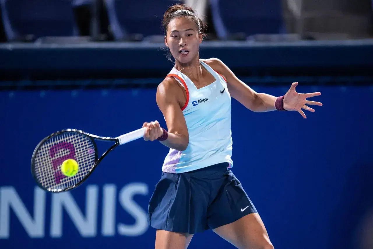 Zheng Qinwen w akcji podczas meczu z tenis. Skupiona na uderzeniu, z rakietą w dłoni.