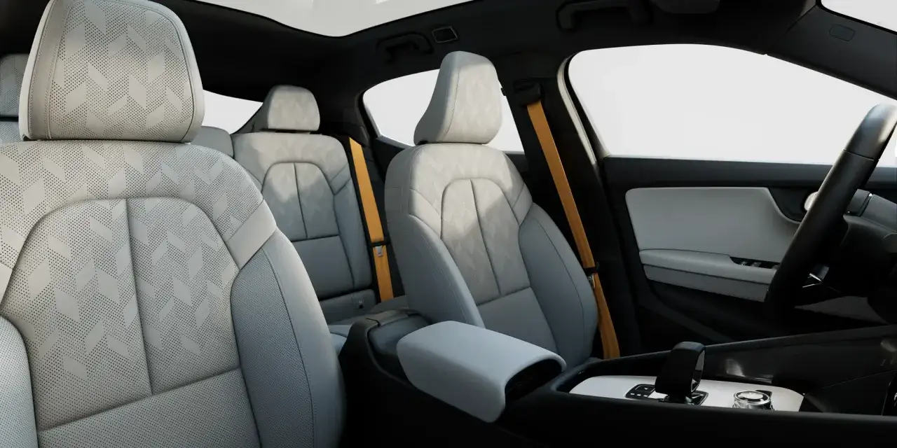 Interiören i en Polestar 2, med ljusa säten med mönster och gula säkerhetsbälten. En spännande polestar 2 test.