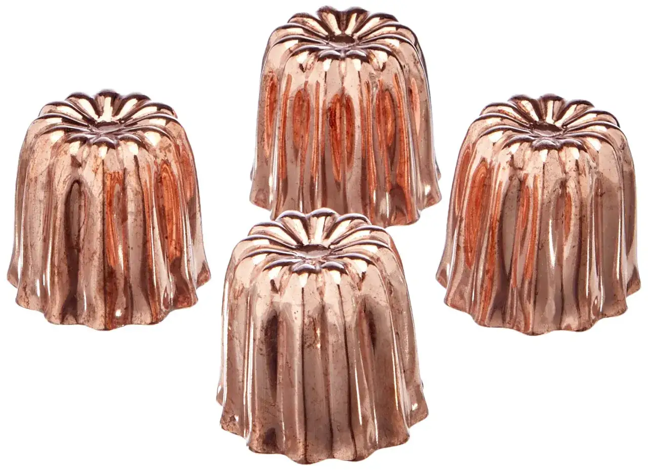 Quatre moules en cuivre pour cannel&eacute;s, pr&ecirc;ts pour une recette gourmande.