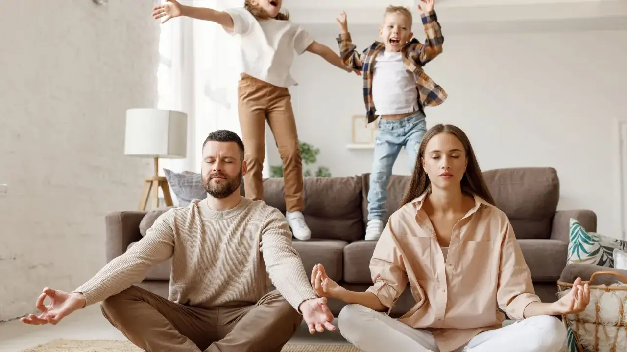 Eltern meditieren, w&auml;hrend Kinder auf dem Sofa toben. Ein Beispiel, warum meditieren hilft, Gelassenheit zu bewahren.
