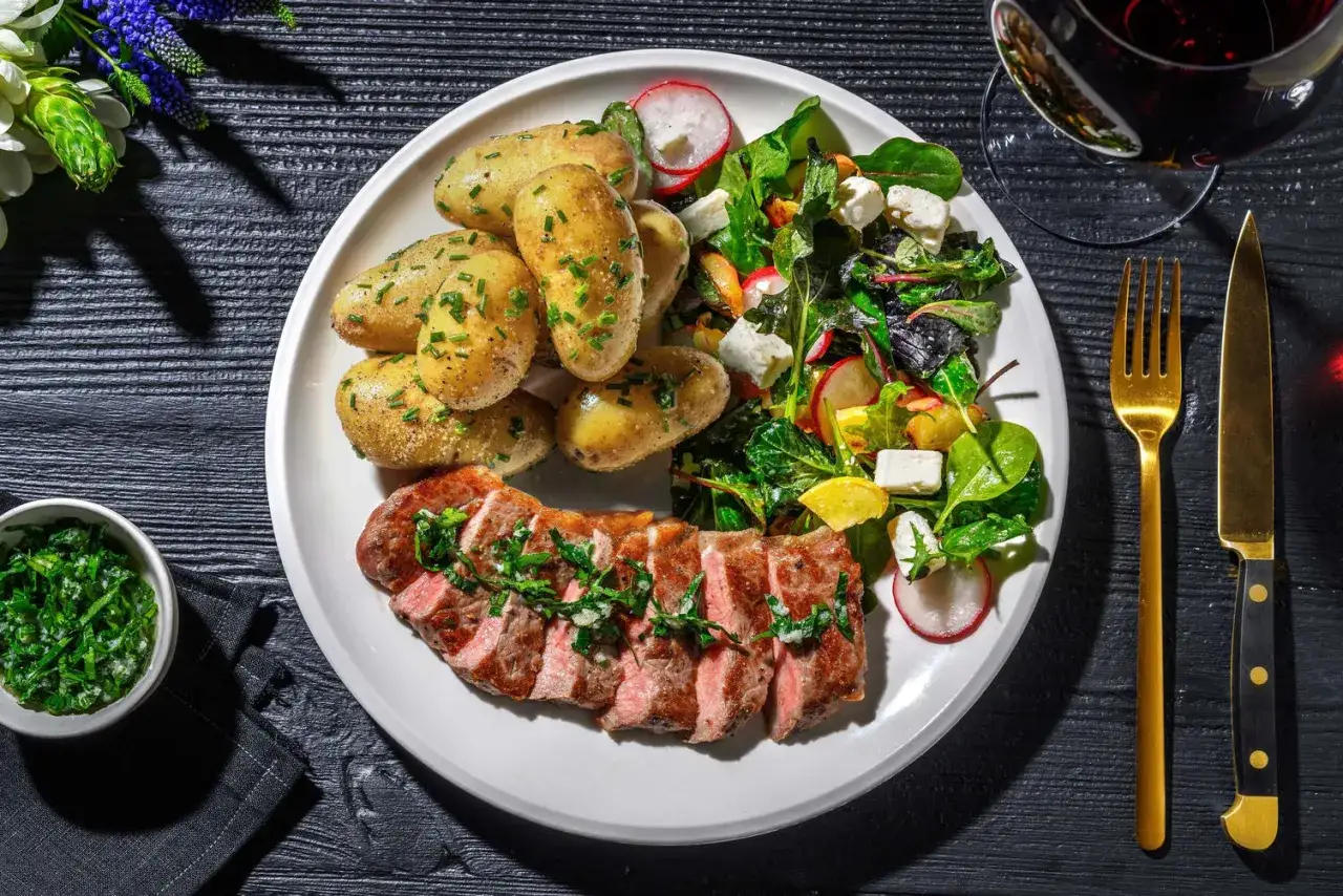 En saftig biff med en härlig örtig kappa, serverad med småpotatis och en fräsch sallad. En perfekt måltid!