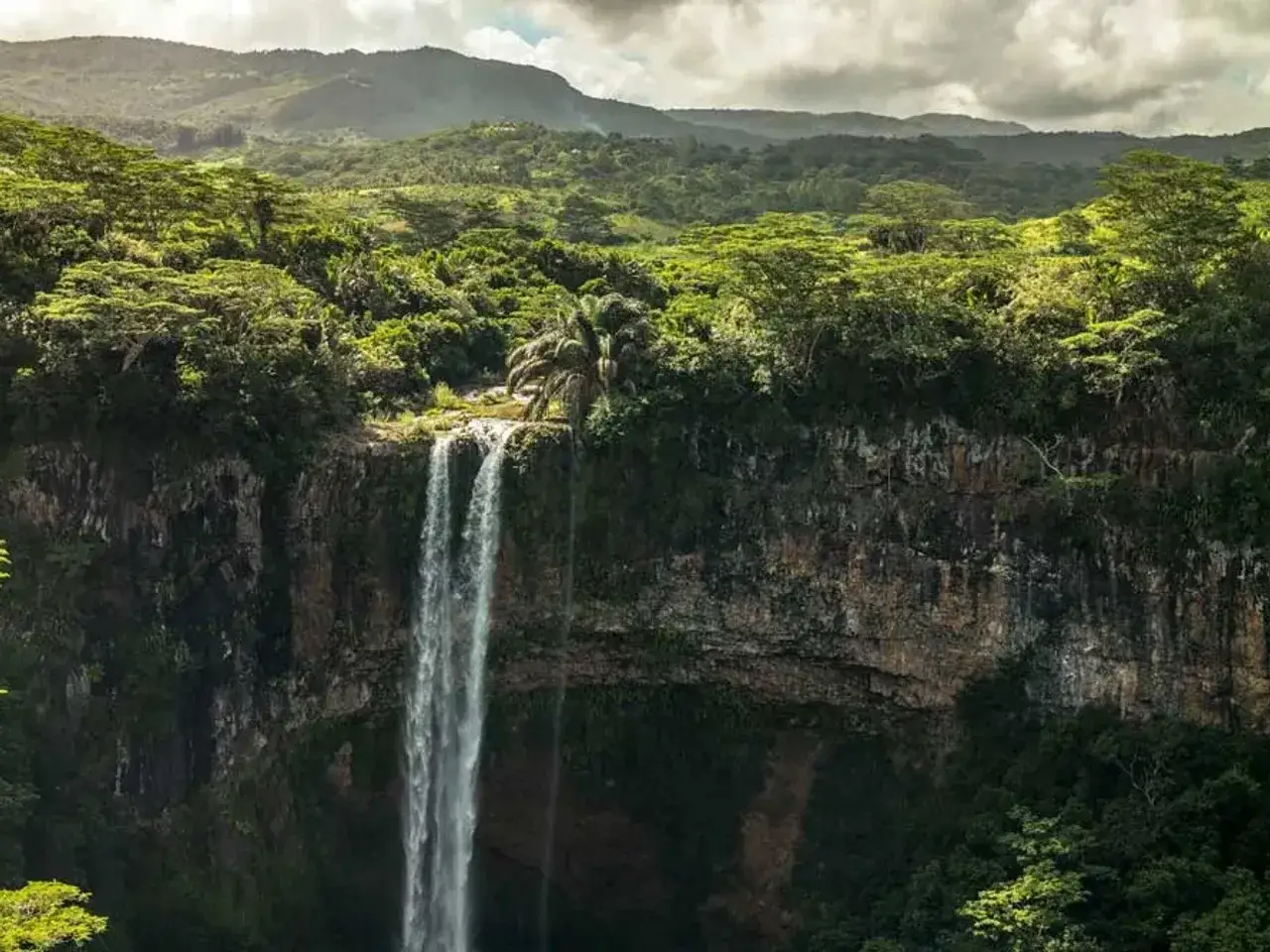 Cascada exuberante en Isla Mauricio, rodeada de vegetaci&oacute;n tropical y monta&ntilde;as. Definitivamente merece la pena viajar a Isla Mauricio para ver esta maravilla natural.