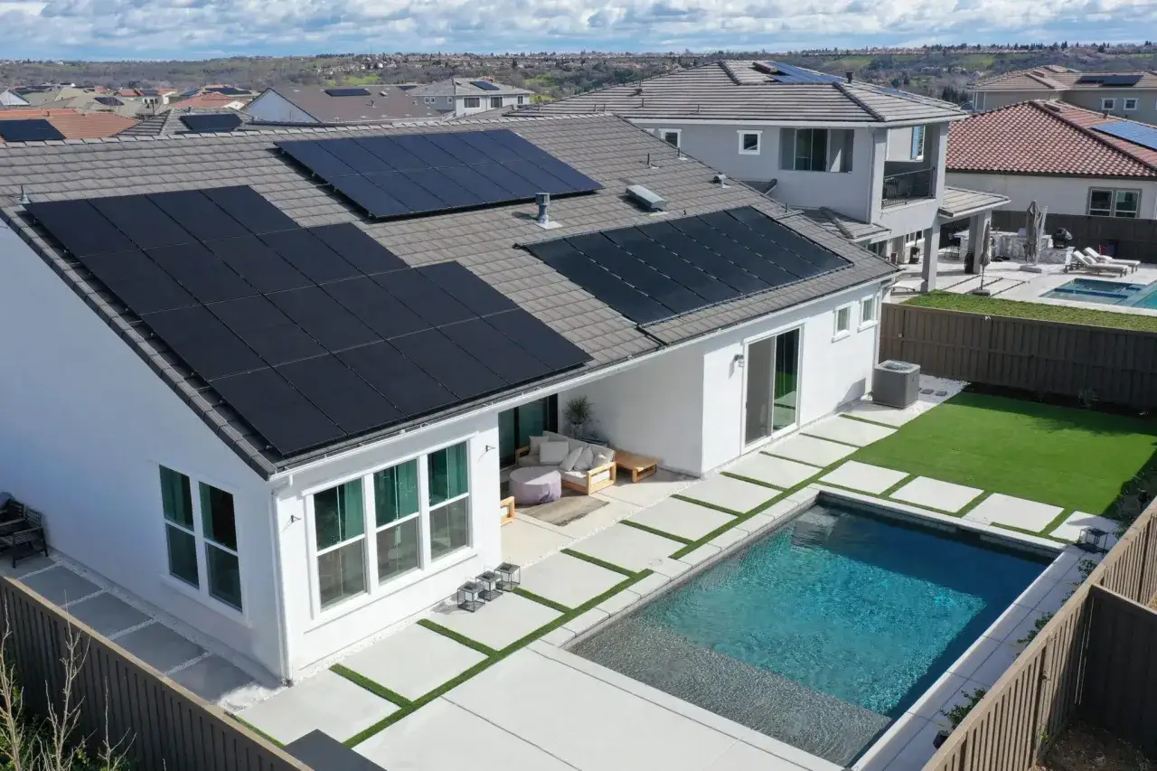 Modernes Haus mit Pool und Solaranlage auf dem Dach, das den KfW 70 Standard erf&uuml;llt.