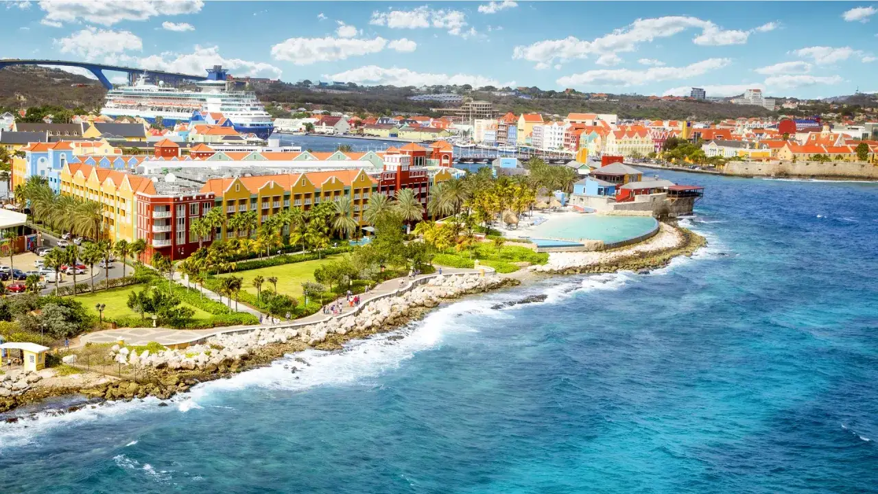 Kolorowe budynki, palmy i turkusowe morze na Curacao. Czy na Curacao potrzebny jest paszport? Tak, dla większości podróżnych.