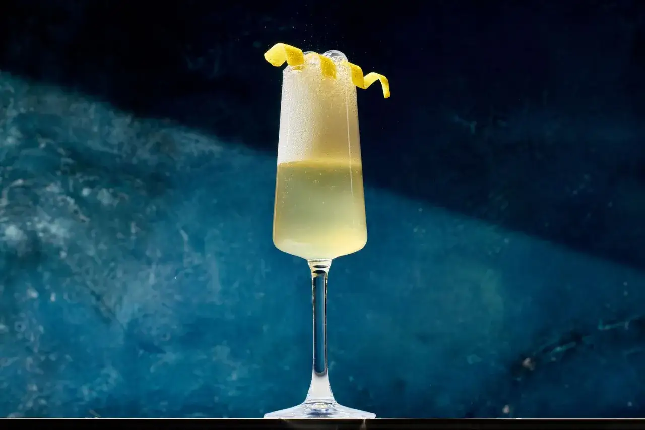 Ein erfrischender French 75 Cocktail mit Zitronenzeste. Das perfekte Rezept für einen eleganten Drink.
