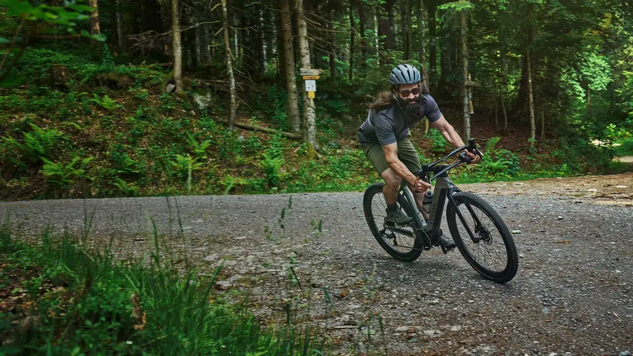 Mężczyzna na rowerze w lesie. Ile kalorii spala się na 18 km na rowerze?