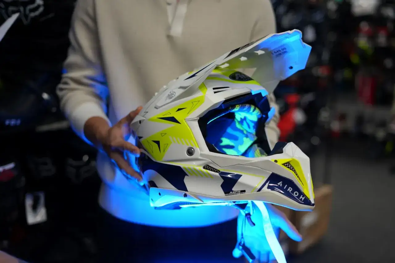 Biało-żółte kaski enduro z niebieskim podświetleniem, gotowe na ekstremalne wyzwania.