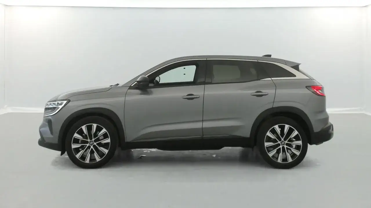 Vue latérale d'un SUV gris, le Renault Austral, montrant ses dimensions élégantes et ses roues distinctives.