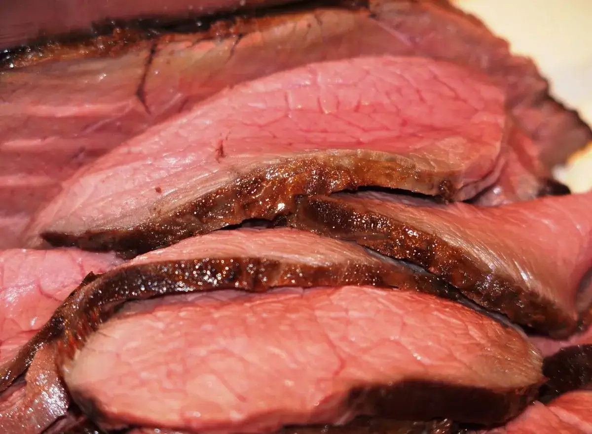 Tranches de rosbeef juteuses, parfaitement saisies, révélant une cuisson rosée idéale. Un délice pour les yeux et les papilles.